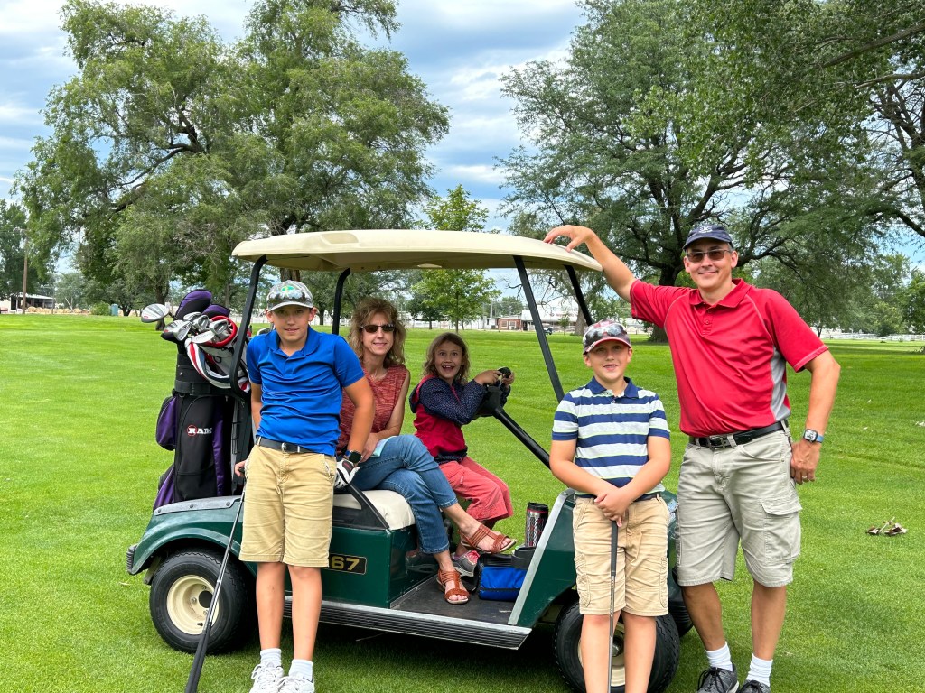 Family with golf cart on golf course